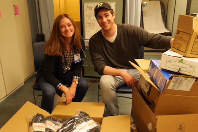 Katie Machado (left) and Henry Carter (right), co-directors of the Clinic Leadership Board, prepare supplies for the Shelter Clinic's Health Fair in June 2019.