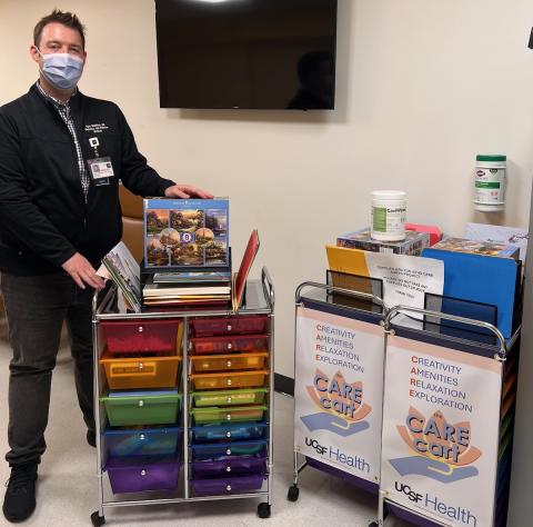 Geriatric fellow Ryan McMahon poses with a Thomas Kinkade puzzle, one of the items in the CARE carts that help patients experience Creativity, Amenities, Relaxation and Exploration. 